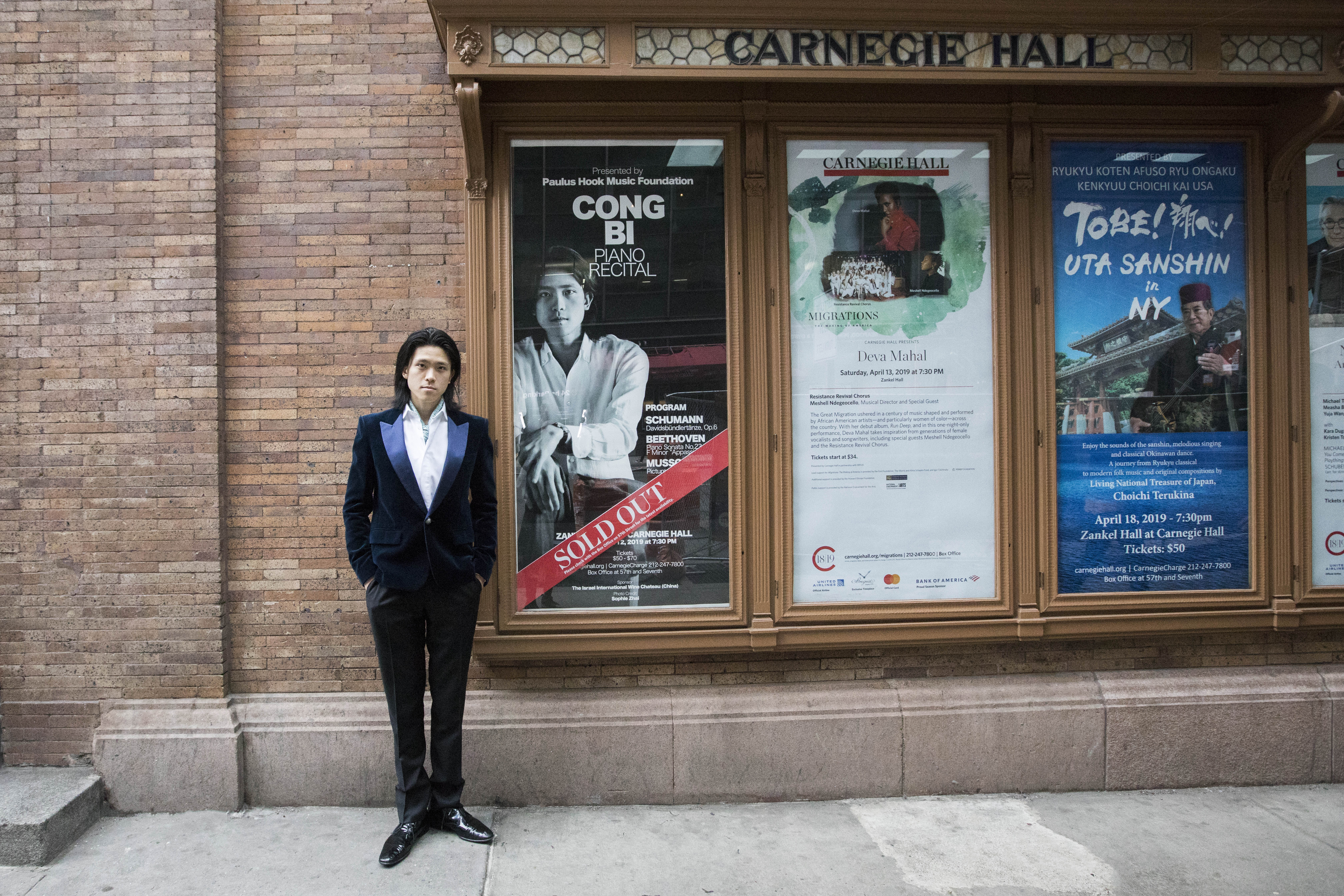【毕聪在卡内基音乐厅售罄演出票海报前】